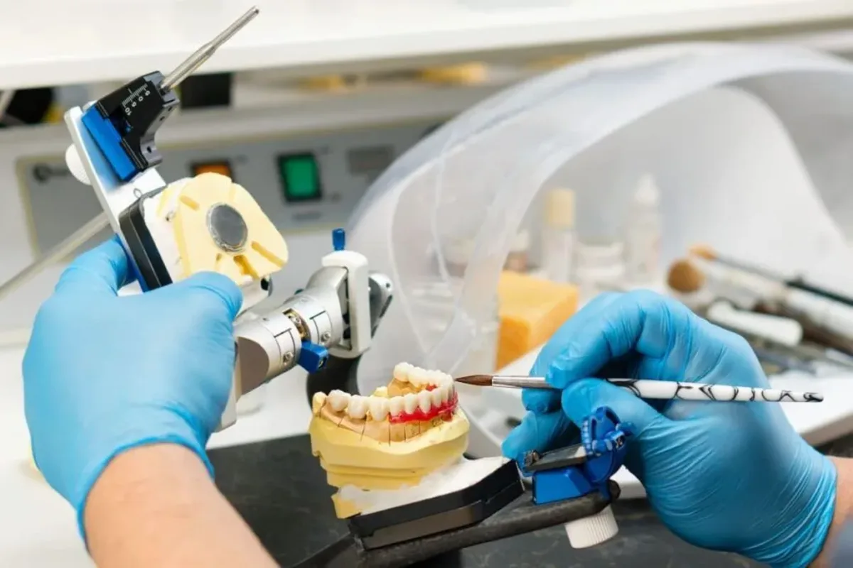 Tehnician dentar lucrând la o proteză în laboratorul de protetică