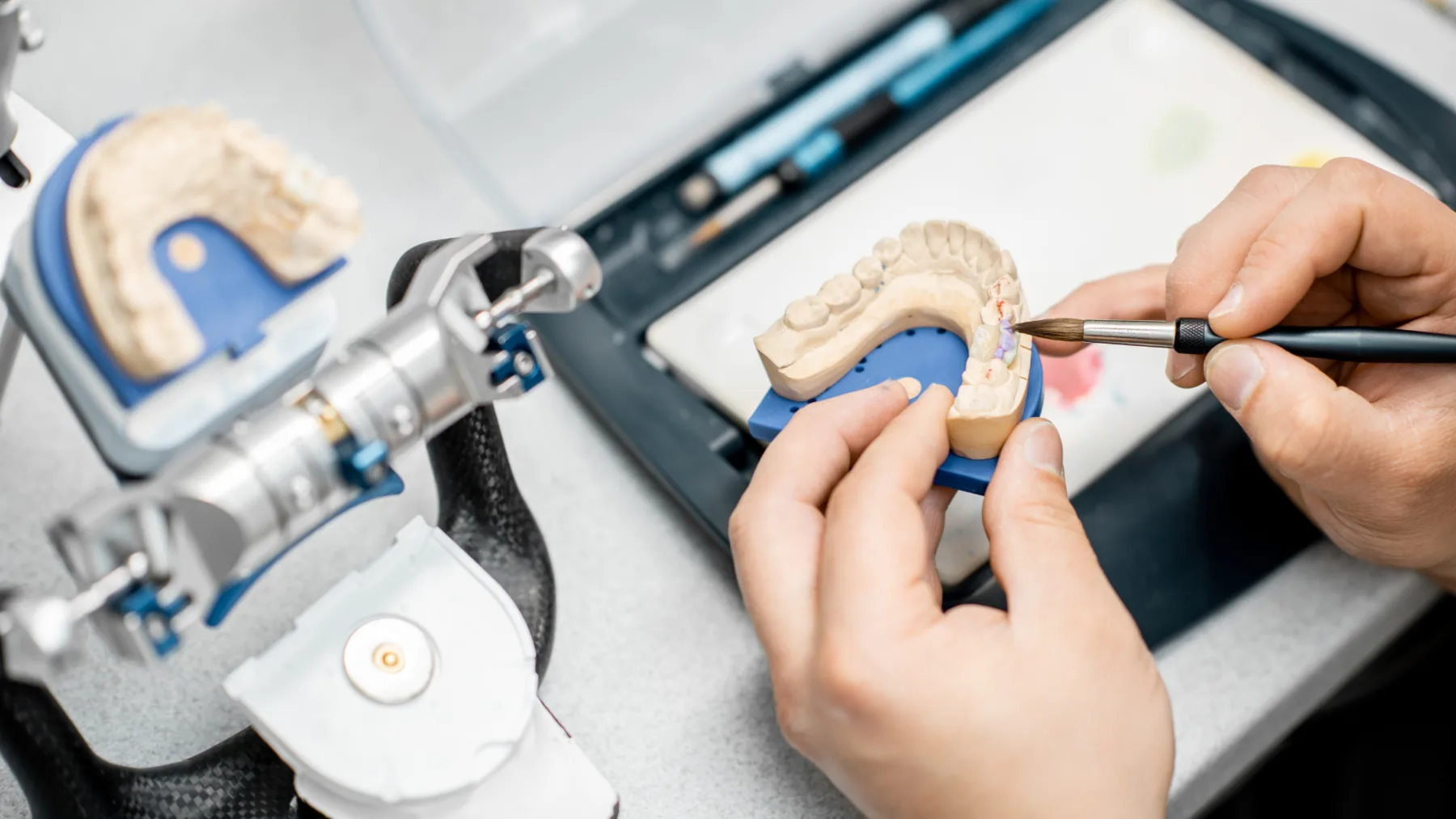 Tehnician dentar realizând stratificarea ceramică a unei lucrări protetice în laboratorul Alex Dent Cosmetics
